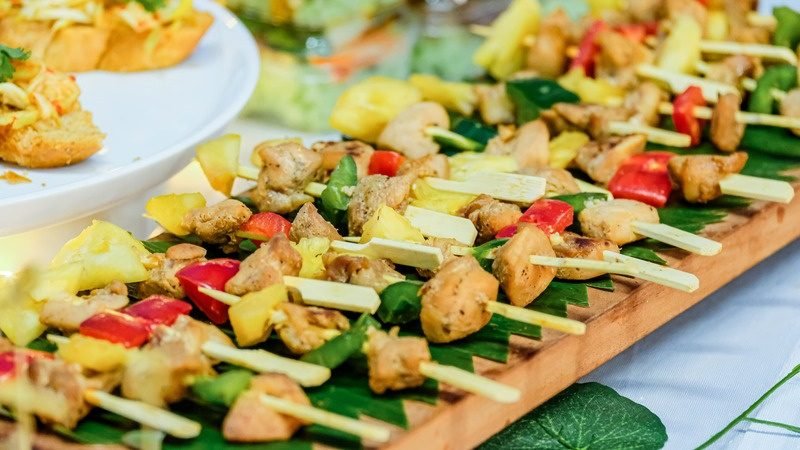 Chicken and pineapple skewers on a wooden board